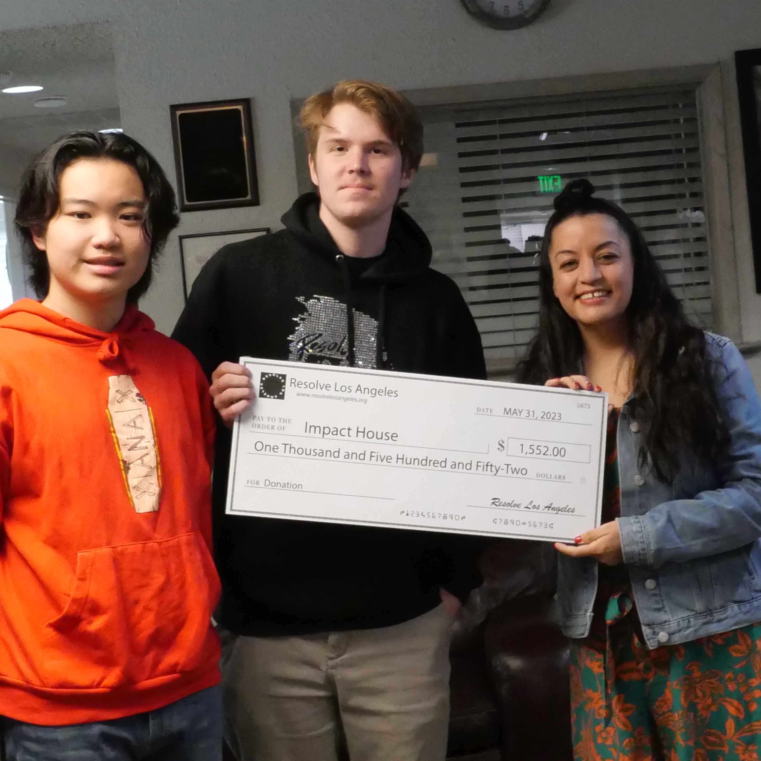 Our team donating $1,552 to Impact House recovery center after our successful fashion show